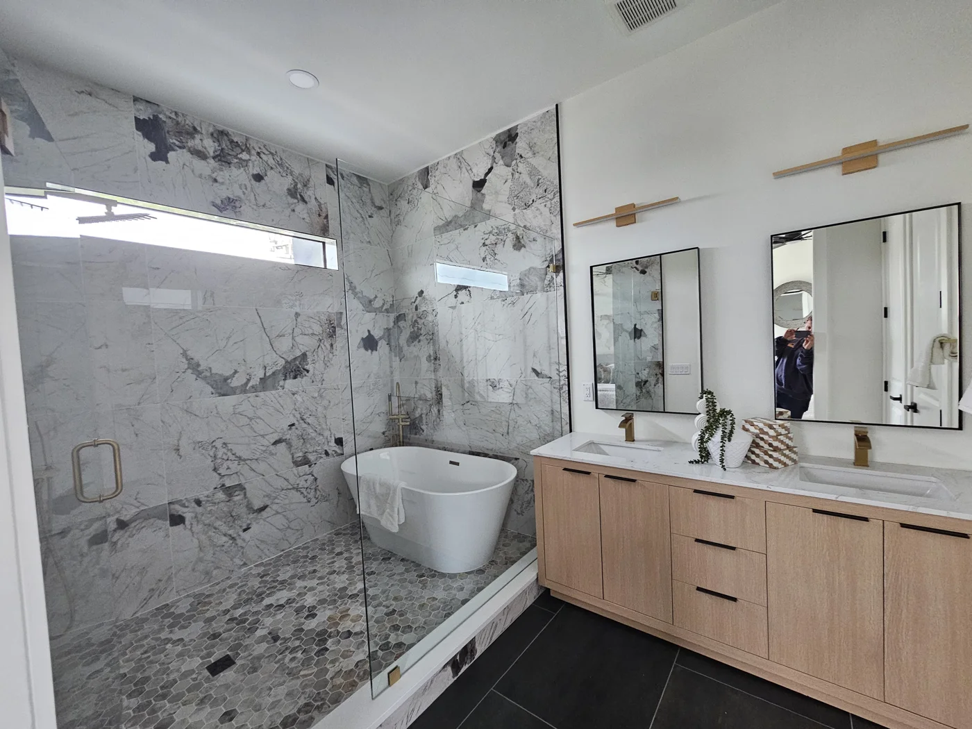 Graham Group primary bathroom with a freestanding tub and glass shower